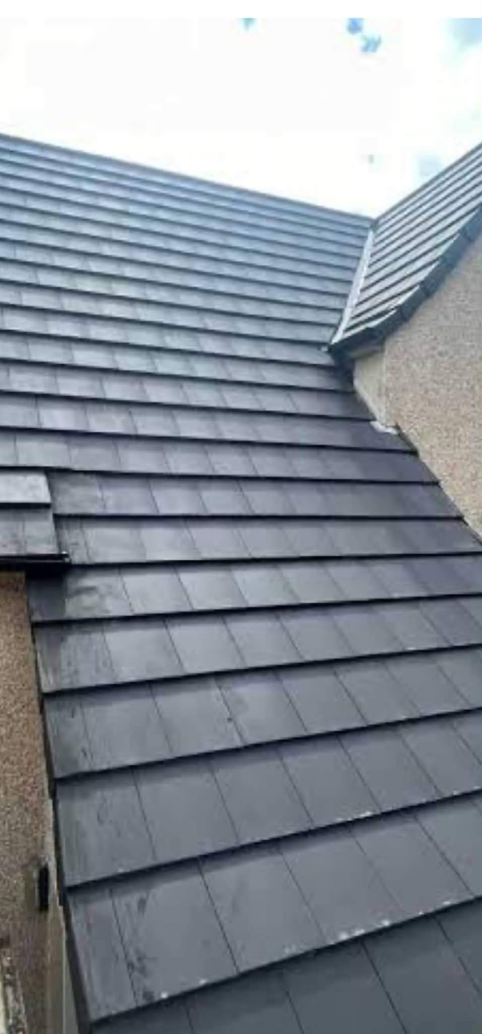 Neatly finished hip roof showing freshly laid tile courses