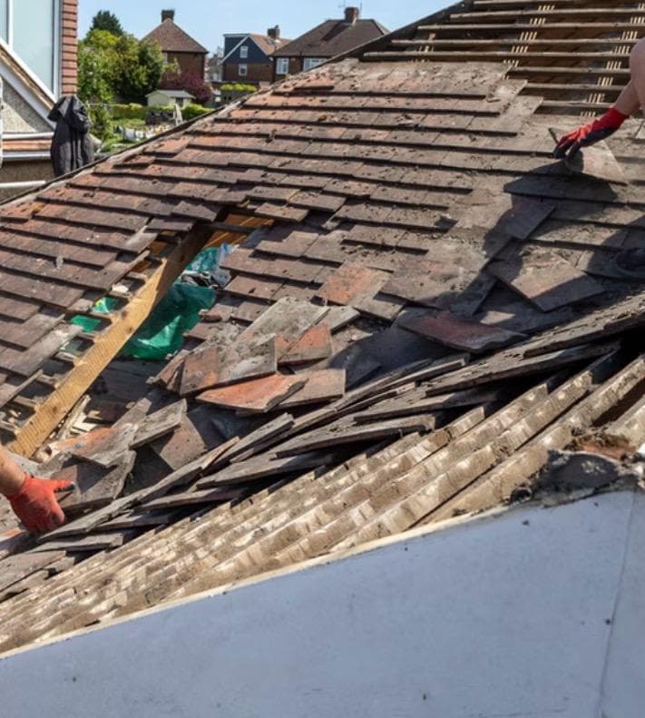 Roofers stripping out old tiles during a full re-roof
